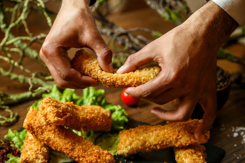 A plate of crispy chicken tenders and golden fries served with dipping sauces, showcasing the ultimate homemade comfort food pairing.