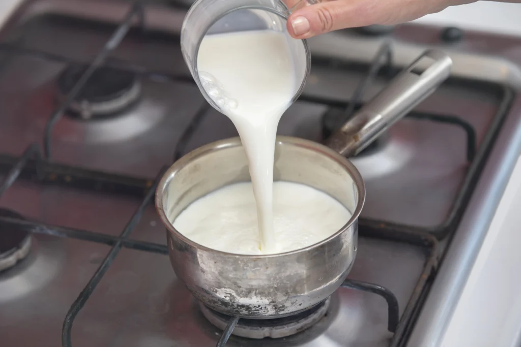 Visual: Image of milk boiling in a pan with sugar and condensed milk being added.
